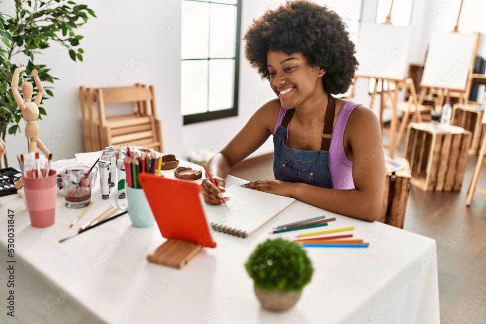 Young african american woman smiling confident looking touchpad drawing at art studio Young african american woman smiling confident looking touchpad drawing at art studio