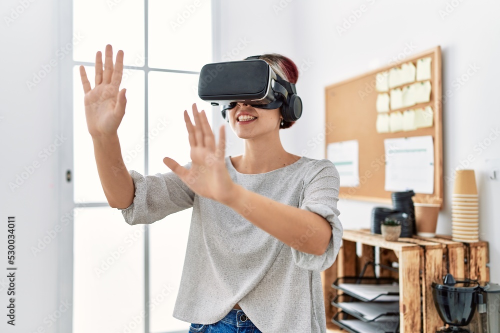 Young caucasian businesswoman smiling happy using virtual reality glasses at the office. Young caucasian businesswoman smiling happy using virtual reality glasses at the office.
