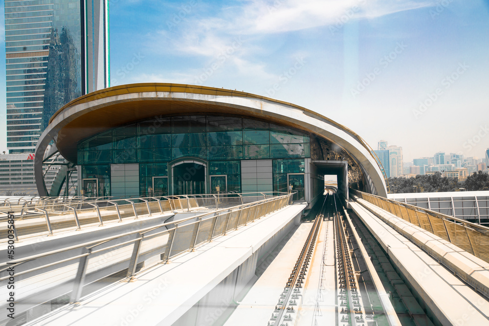 Fototapeta premium Dubai, UAE. Dubai tube, metro railway track, train station and City buildings