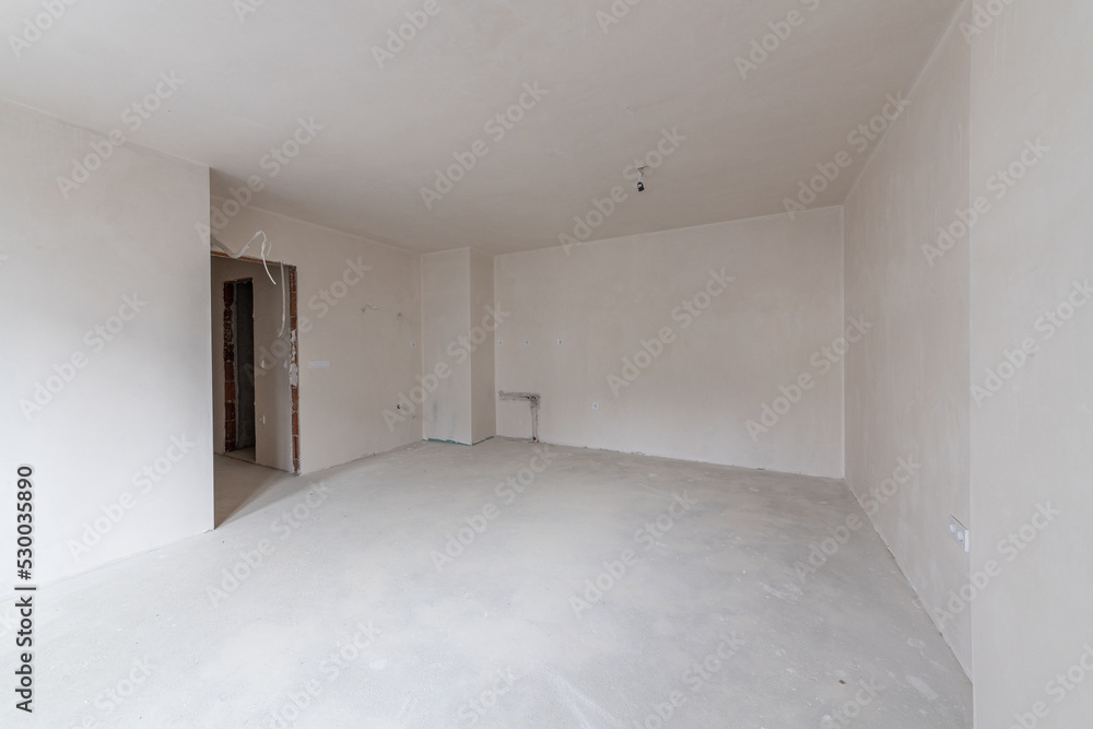 New empty room under construction. Plaster walls. New home. Concrete walls. Interior renovation. New empty room under construction. Plaster walls. New home. Concrete walls. Interior renovation.
