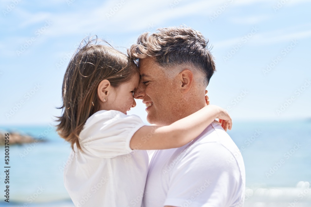 Father and daughter smiling confident hugging each other at seaside Father and daughter smiling confident hugging each other at seaside