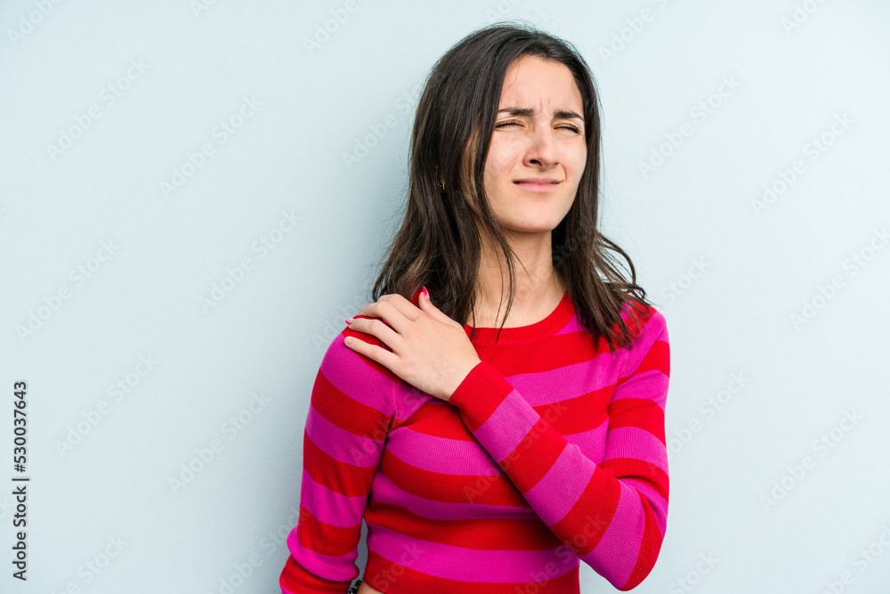 Young caucasian woman isolated on blue background having a shoulder pain. Young caucasian woman isolated on blue background having a shoulder pain.