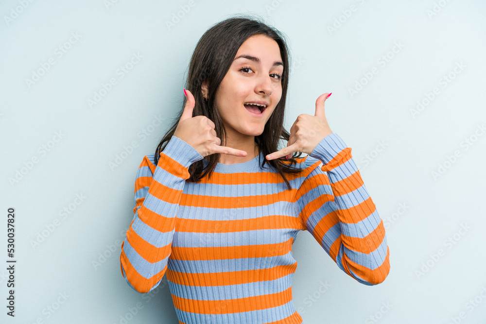 Young caucasian woman isolated on blue background showing a mobile phone call gesture with fingers. Young caucasian woman isolated on blue background showing a mobile phone call gesture with fingers.