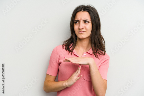 Young caucasian woman isolated on white background showing a timeout gesture.