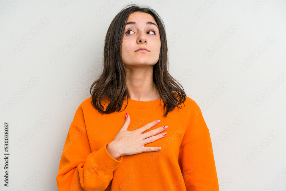 Young caucasian woman isolated on white background taking an oath, putting hand on chest.