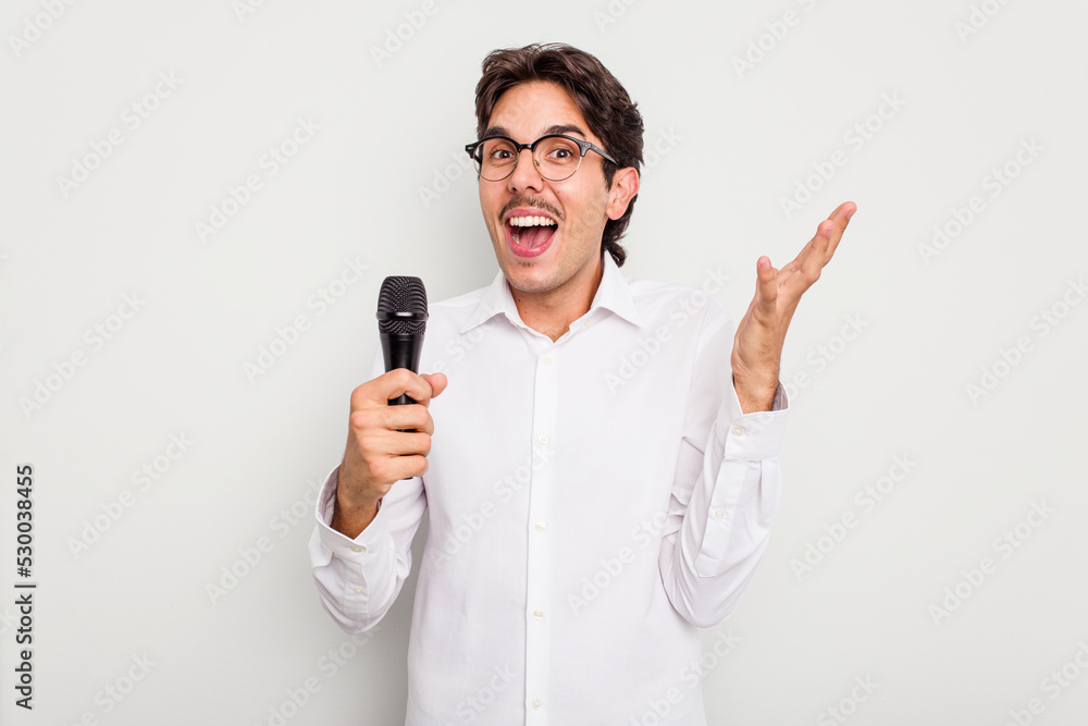 Young hispanic singer man isolated on white background receiving a pleasant surprise, excited and raising hands. Young hispanic singer man isolated on white background receiving a pleasant surprise, excited and raising hands.