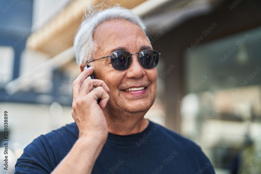 Middle age grey-haired man smiling confident talking on the smartphone at street Middle age grey-haired man smiling confident talking on the smartphone at street