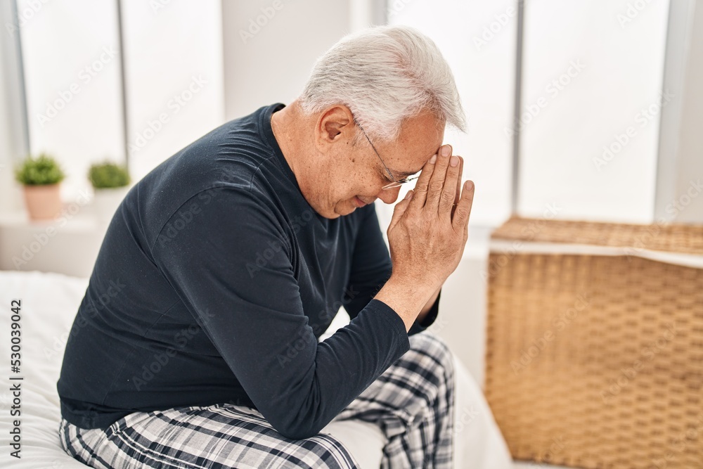 Senior man stressed sitting on bed at bedroom Senior man stressed sitting on bed at bedroom