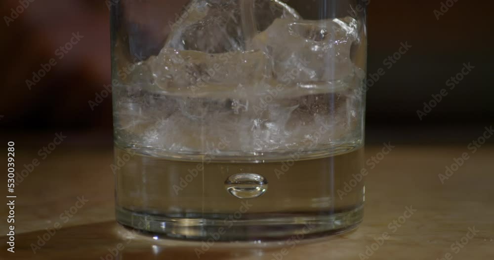 Close-Up Of Barman Pouring a Clear Drink into Glass Close-Up Of Barman Pouring a Clear Drink into Glass