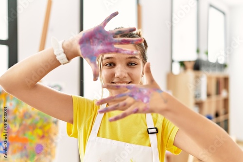 Adorable girl smiling confident showing painted palm hands at art studio