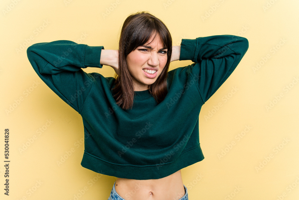 Young caucasian woman isolated on yellow background suffering neck pain due to sedentary lifestyle. Young caucasian woman isolated on yellow background suffering neck pain due to sedentary lifestyle.