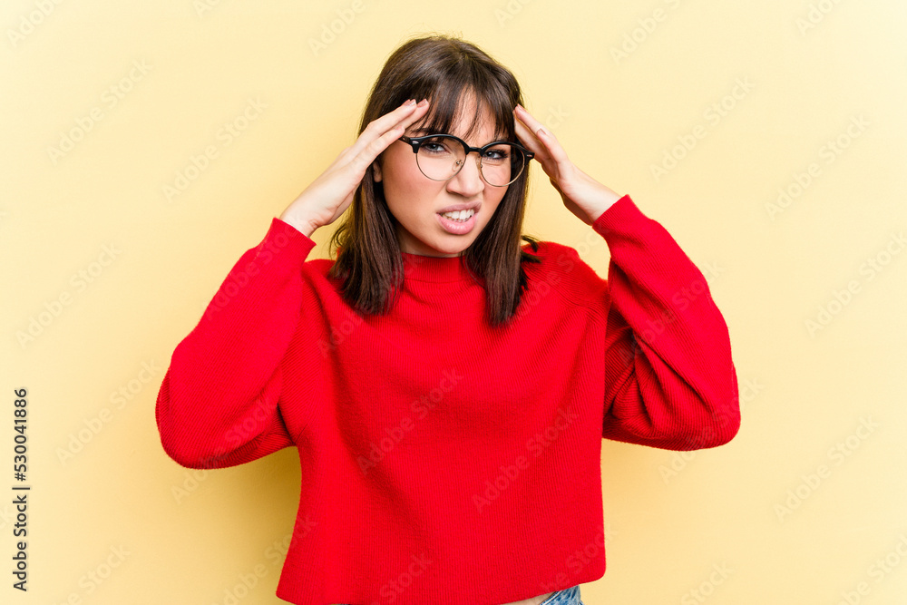 Young caucasian woman isolated on yellow background touching temples and having headache. Young caucasian woman isolated on yellow background touching temples and having headache.