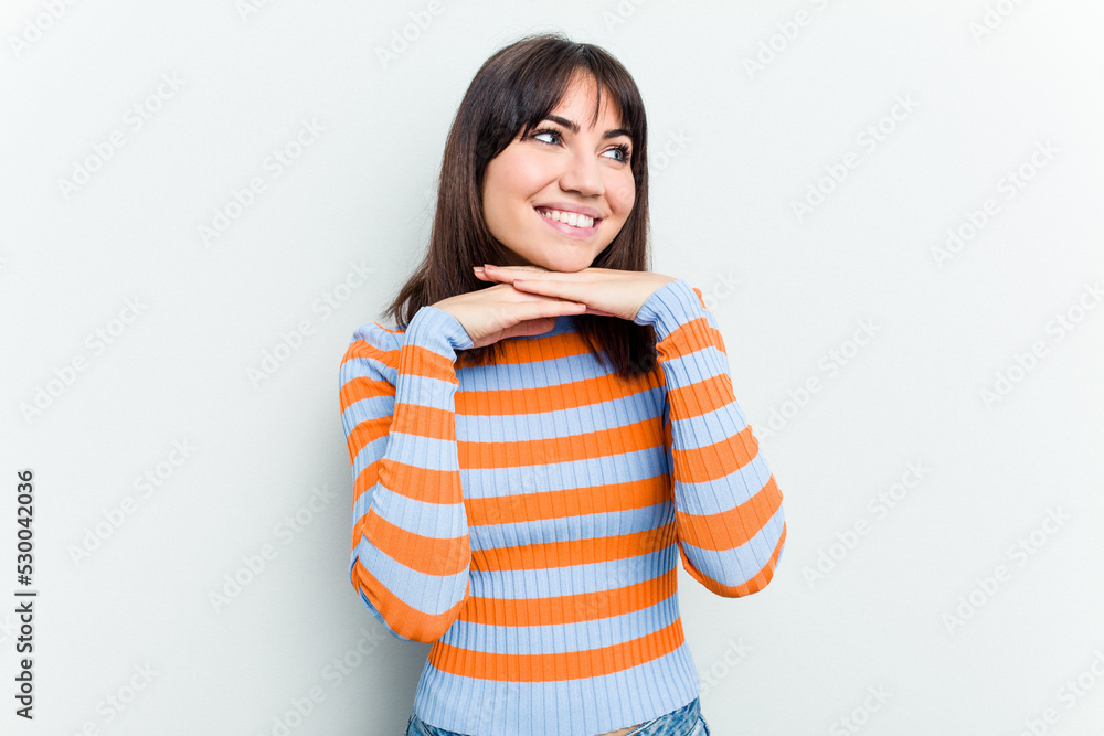 Young caucasian woman isolated on white background keeps hands under chin, is looking happily aside. Young caucasian woman isolated on white background keeps hands under chin, is looking happily aside.