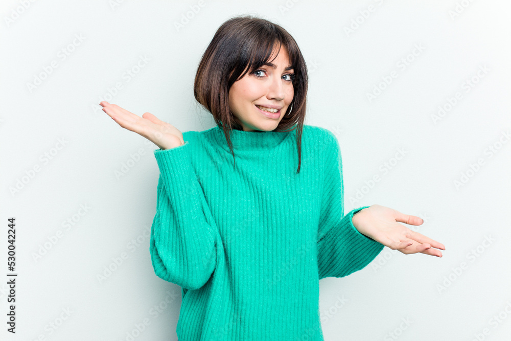Young caucasian woman isolated on white background confused and doubtful shrugging shoulders to hold a copy space. Young caucasian woman isolated on white background confused and doubtful shrugging shoulders to hold a copy space.