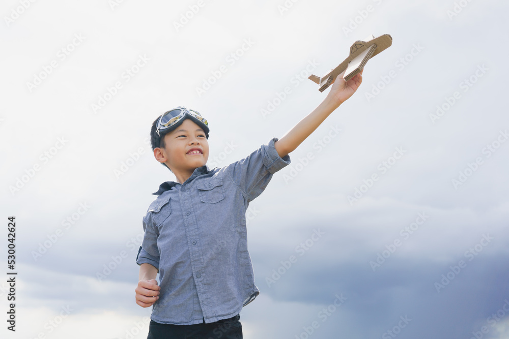 Asian cute boy enjoy and playful with cardboard airplane over the mountain. Asian cute boy enjoy and playful with cardboard airplane over the mountain.