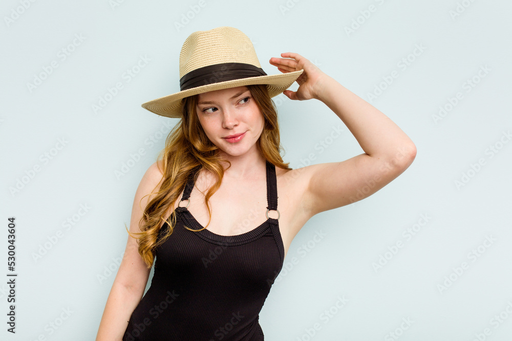 Young caucasian woman going to the beach isolated on blue background touching back of head, thinking and making a choice. Young caucasian woman going to the beach isolated on blue background touching back of head, thinking and making a choice.
