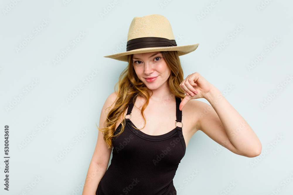 Young caucasian woman going to the beach isolated on blue background feels proud and self confident, example to follow.