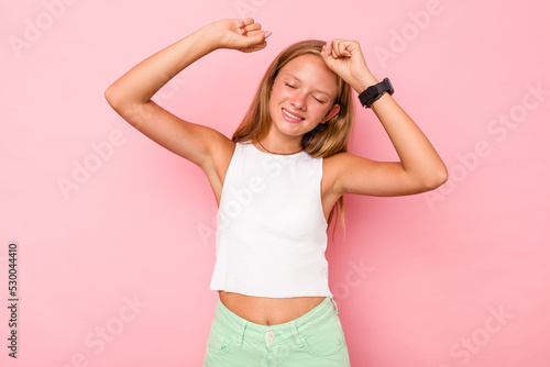Caucasian teen girl isolated on pink background celebrating a special day, jumps and raise arms with energy.