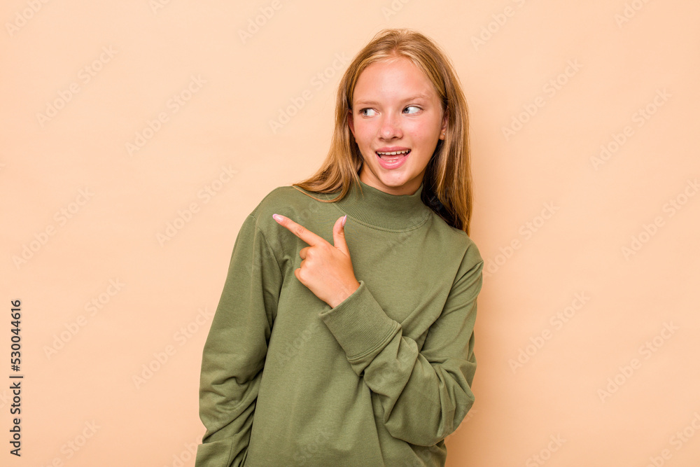 Caucasian teen girl isolated on beige background looks aside smiling, cheerful and pleasant. Caucasian teen girl isolated on beige background looks aside smiling, cheerful and pleasant.