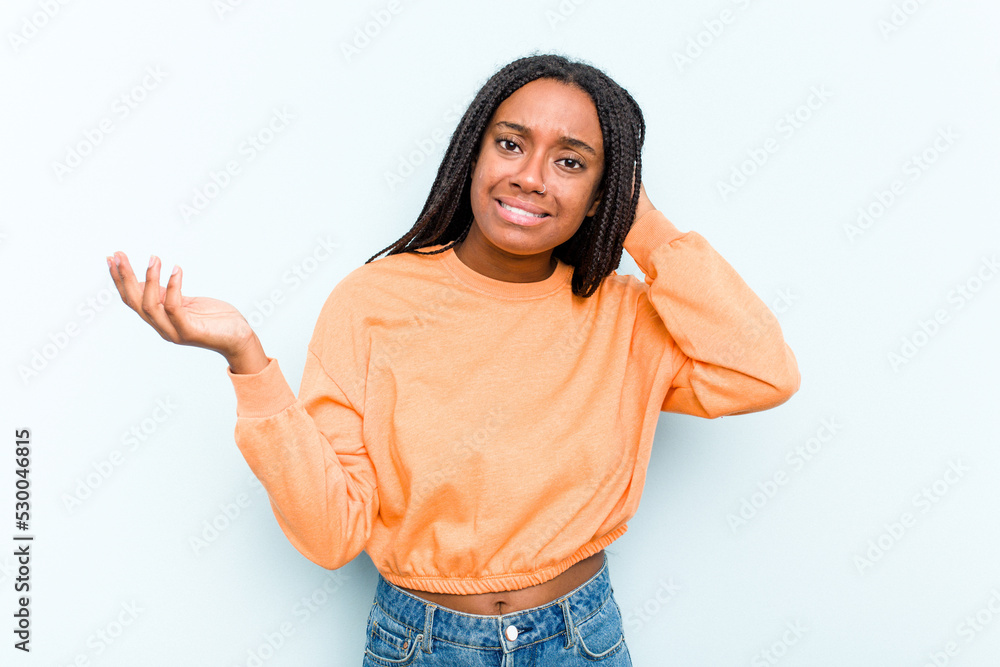 Young African American woman with braids hair isolated on blue background screaming with rage. Young African American woman with braids hair isolated on blue background screaming with rage.