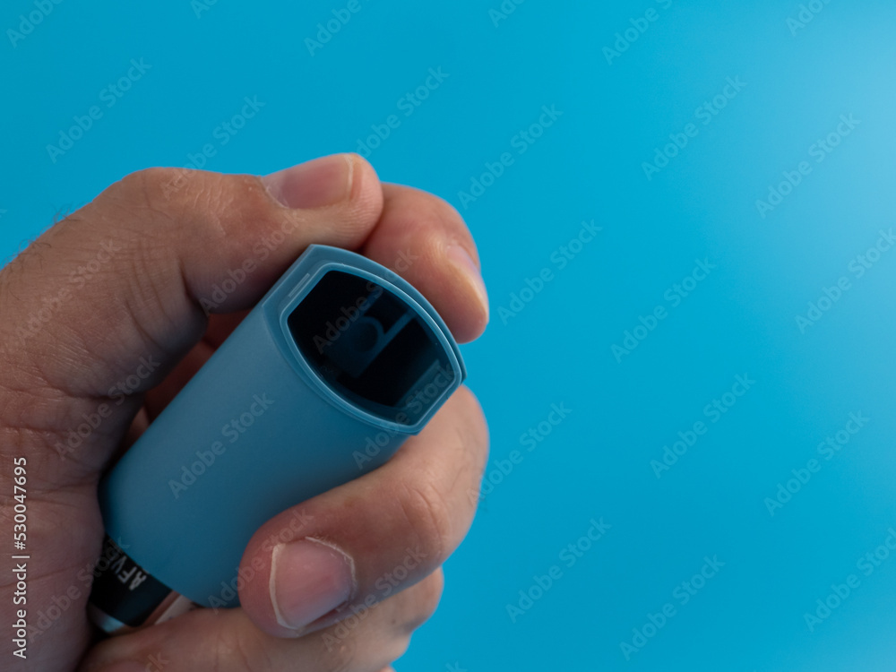 Asthma medicine. Inhaler for the treatment of bronchial asthma on a blue background. Asthma medicine. Inhaler for the treatment of bronchial asthma on a blue background.