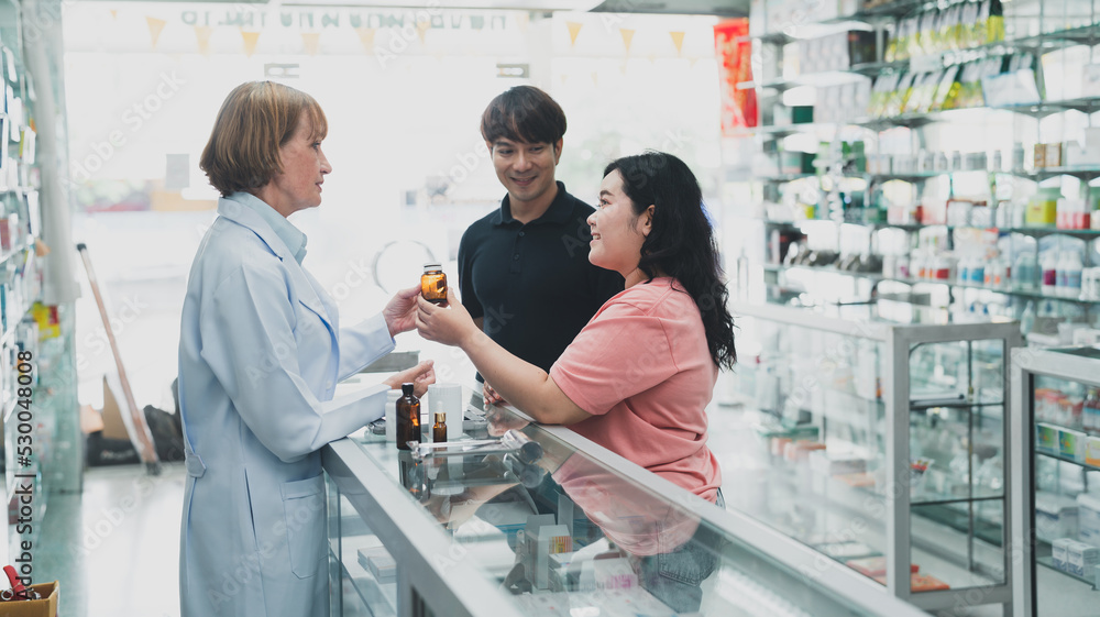 Pharmacists provide drug advice to male and female customers.female doctor healt care of pharmacy customer health.doctor giving prescription. Pharmacists provide drug advice to male and female customers.female doctor healt care of pharmacy customer health.doctor giving prescription.