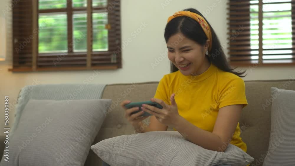 Young Asian female soccer fans watching soccer match on mobile phone. Young Asian female soccer fans watching soccer match on mobile phone.