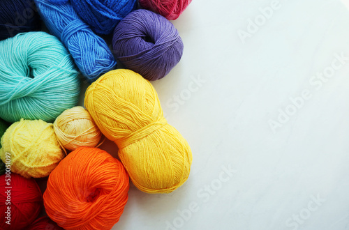 Composition with rainbow yarn balls on light background 