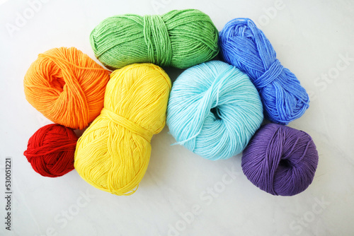 Composition with rainbow yarn balls on light background 