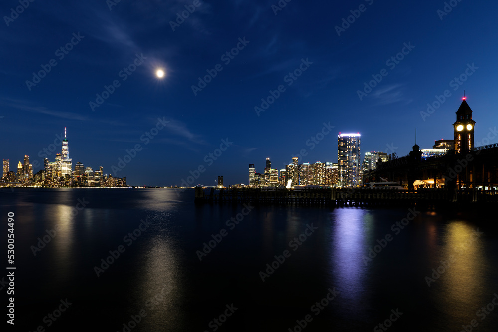 View of Hoboken, NJ Transit Terminal, and skyline of Manhattan at night. High-quality photo