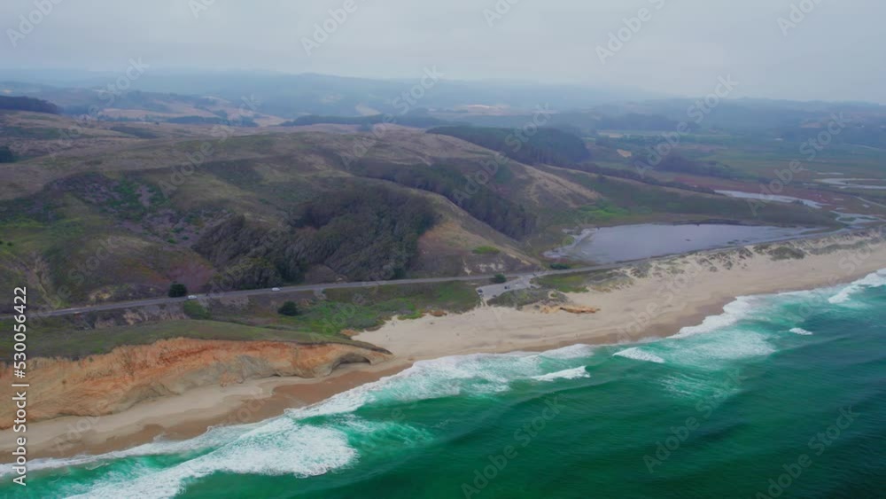 HIgh Aerial view drone shot rotation pan of California coast rock cliffs on a foggy day HIgh Aerial view drone shot rotation pan of California coast rock cliffs on a foggy day