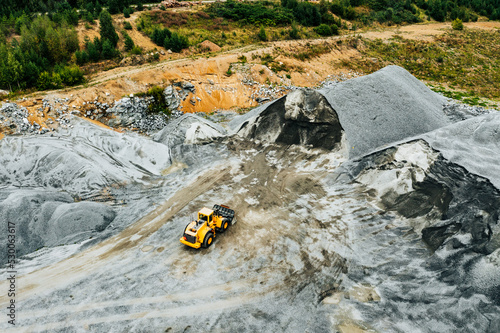 Aerial view of Truck excavator in open sand quarry rubble in Finland. © nblxer