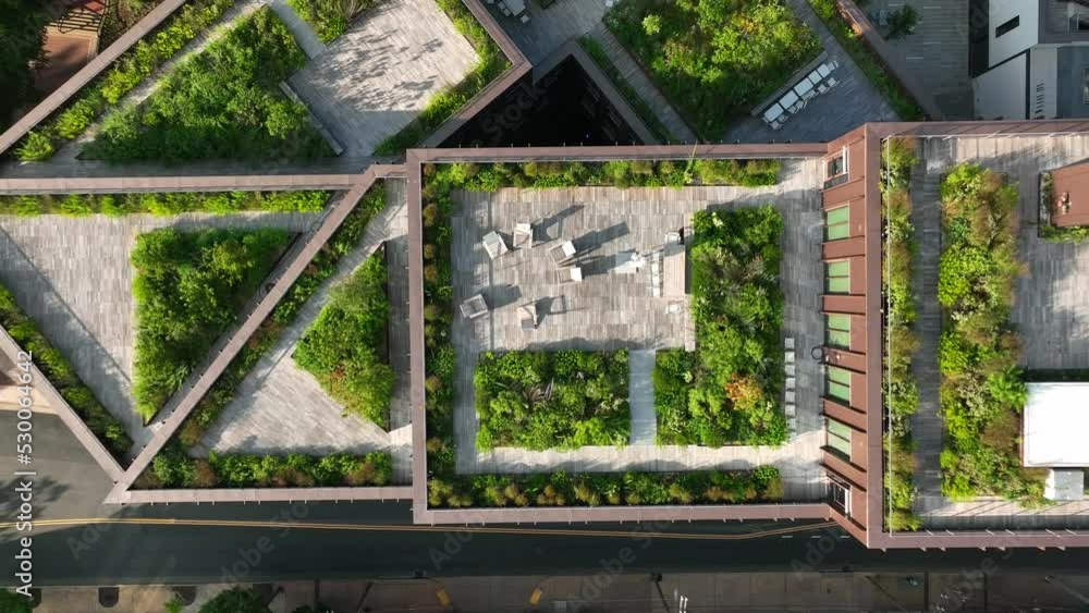 Rising aerial, outdoor living space. Green rooftop garden in urban city ...