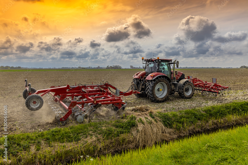 Fototapeta premium Tractor during spring work on the field