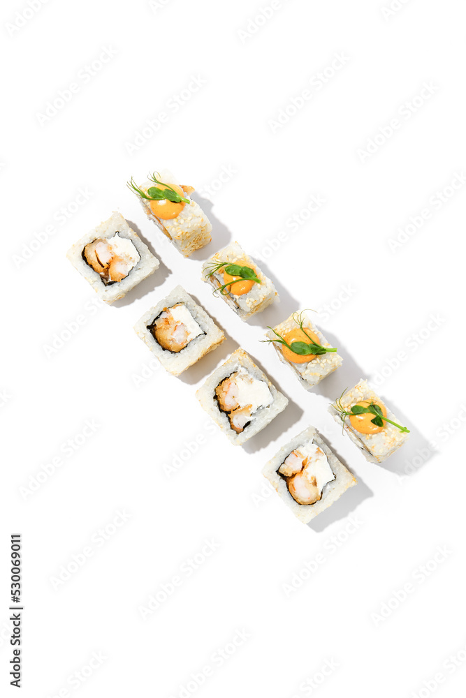Maki sushi with sesame outside, tempura shrimp inside topped spicy sauce and microgreens. Spicy shrimp maki roll isolated on white background Trendy sushi roll with crispy prawn and hard shadows Maki sushi with sesame outside, tempura shrimp inside topped spicy sauce and microgreens. Spicy shrimp maki roll isolated on white background Trendy sushi roll with crispy prawn and hard shadows