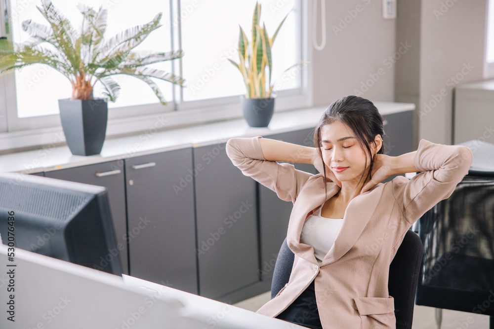 A businesswoman who works in the office looks tired and stressed by pressing her hands A businesswoman who works in the office looks tired and stressed by pressing her hands