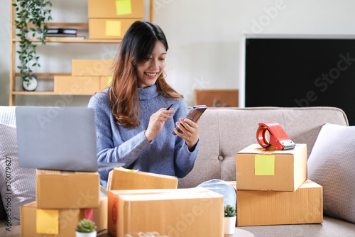 Portrait of a Small Business Startup, SME Owner, Female Entrepreneur work on parcel boxes Receipts and check orders online to prepare boxes. Selling to customers. Online SME business idea.