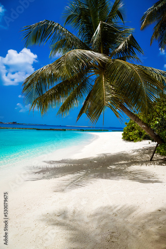Landscape on Maldives island, luxury water villas resort and sandy beach. Beautiful sky and ocean and beach with palms background for summer vacation holiday and travel concept. Tourism.