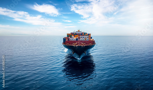Front view of a big container cargo ship travelling over the ocean with copy space photo