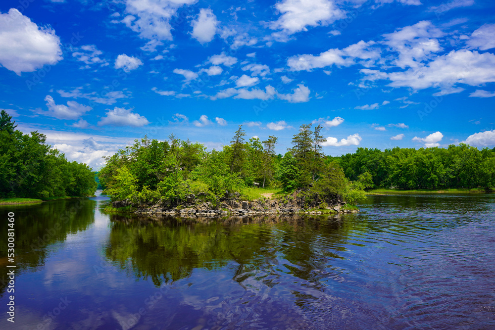 Obraz premium St. Croix River with Green Trees in Summer with Blue Sky