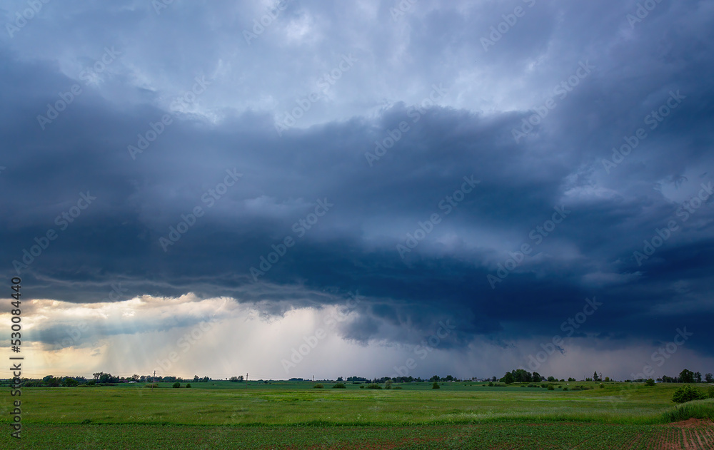 Storm clouds over field, tornadic supercell, extreme weather, dangerous storm Storm clouds over field, tornadic supercell, extreme weather, dangerous storm