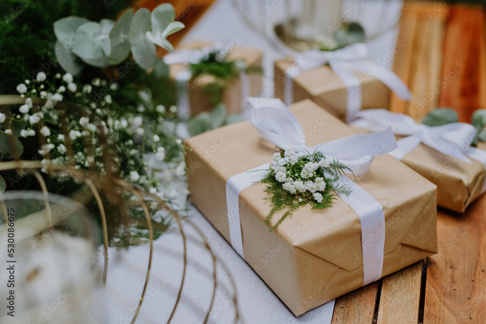 High angle view of wedding gift wrapped in eco paper papckaging and flower decoration. High angle view of wedding gift wrapped in eco paper papckaging and flower decoration.