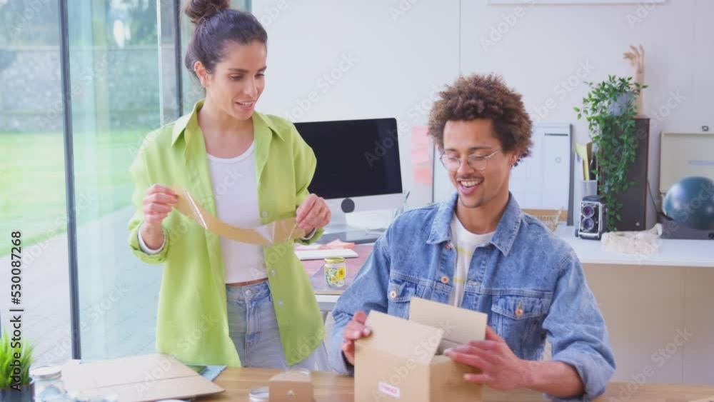 Couple running online candle store from home packaging products for shipping - shot in slow motion Couple running online candle store from home packaging products for shipping - shot in slow motion