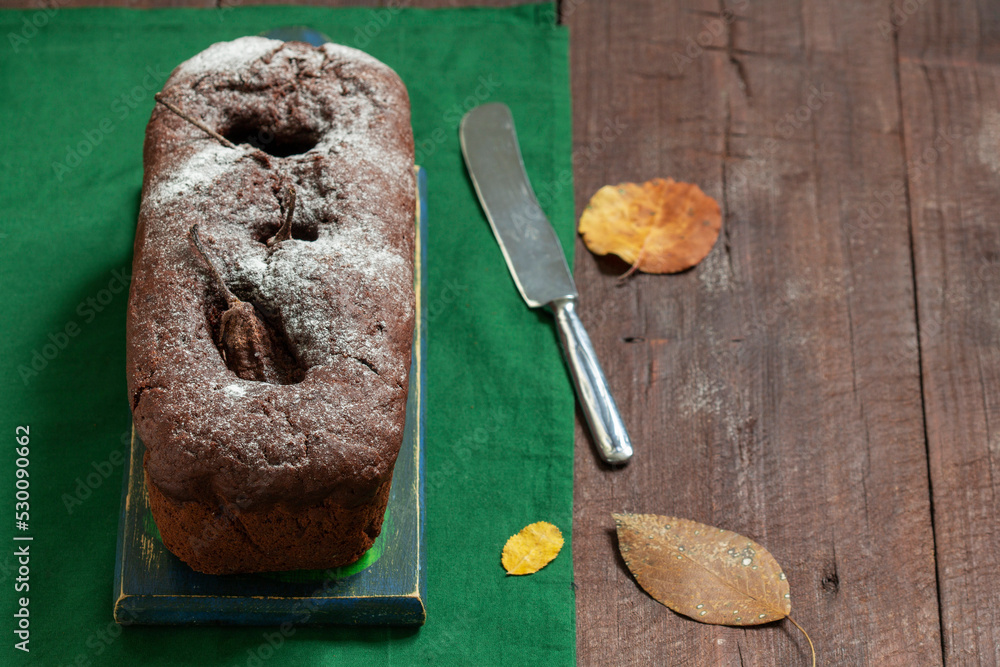 Chocolate pear cake on a green background. Rustic style.