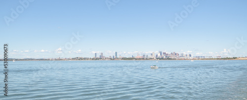 Boats in the harbor with the Boston skyline wide view in the far distance.