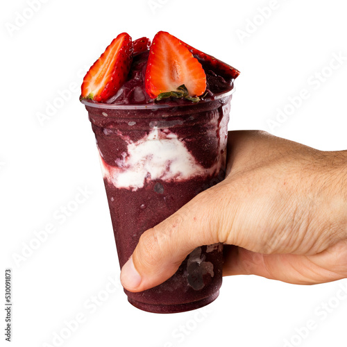 Man holding Brazilian Frozen Açai Berry Ice Cream Smoothie in plastic cup with Strawberries. On a wooden desk and a gray summer background with fruits. Front view for menu and social media
