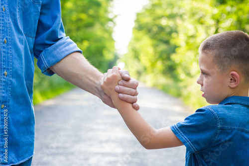 A Hands of happy parent and child on nature on the road in park background