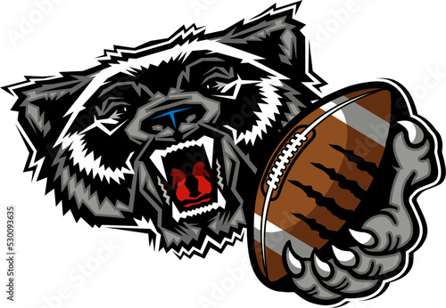 mean wolverine mascot holding football for school, college or league photo