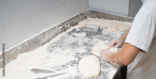 Photography young boy works in the traditional way by folding bread to let it ferment and th