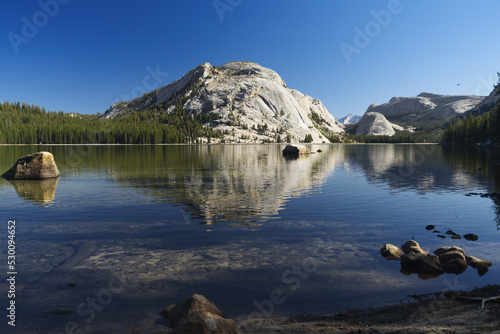 Tenaya Lake in Yosemite National Park, Mariposa County, California, shown in early morning against a clear, blue sky. photo